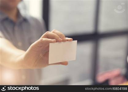 woman's hand holding blank white name card, selective focus and vintage tone
