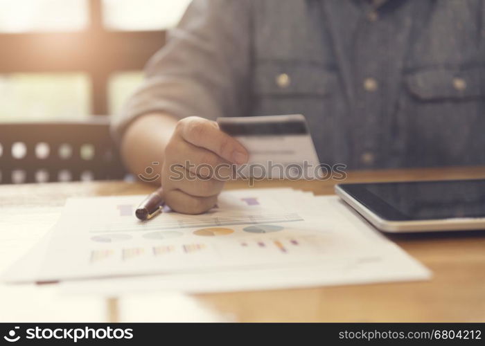 woman's hand holding credit card with tablet for shopping online concept, selective focus and vintage tone