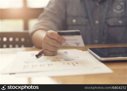 woman's hand holding credit card with tablet for shopping online concept, selective focus and vintage tone