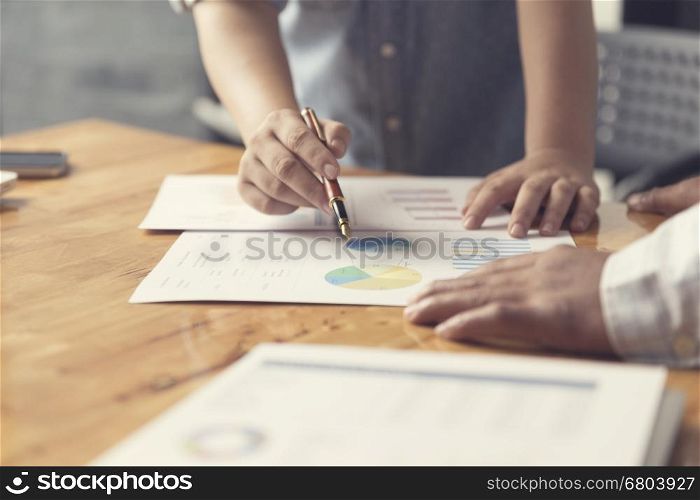 woman's hand holding pen working with business document for working concept, selective focus and vintage tone