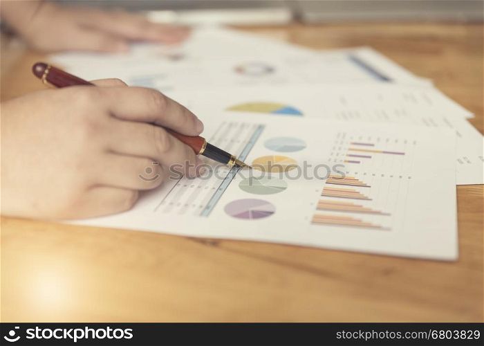 woman's hand holding penworking with business document for working concept, selective focus and vintage tone