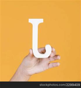woman s hand holding white alphabet j