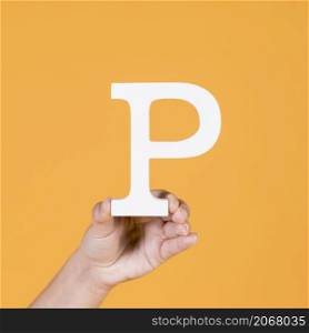 woman s hand holding white letter p