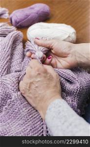 woman s hand making wool tassel