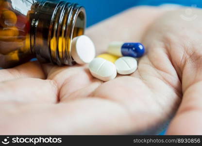 Woman’s hand pours the medicine pills out of the bottle