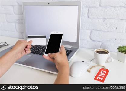 woman s hand shopping online through mobile phone laptop
