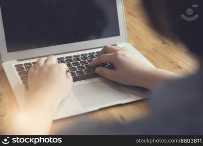 woman's hand typing with laptop computer notebook for working concept, selective focus and vintage tone