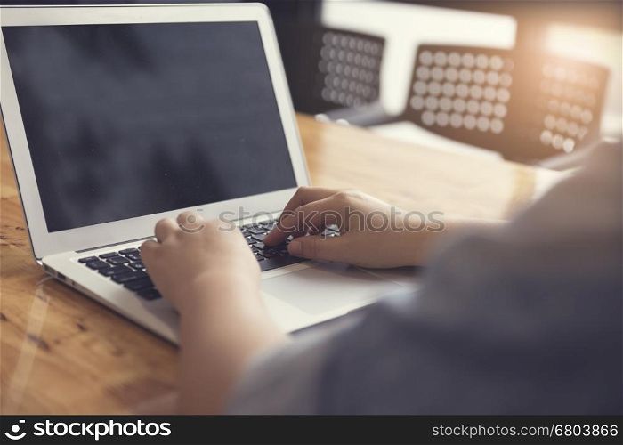 woman's hand typing with laptop computer notebook for working concept, selective focus and vintage tone