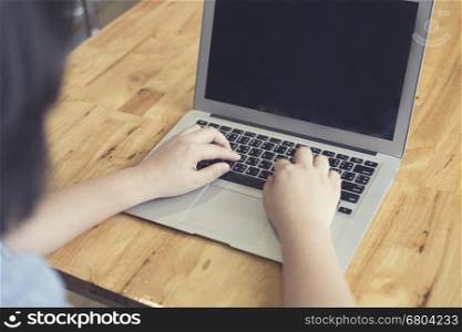 woman's hand typing with laptop computer notebook for working concept, selective focus and vintage tone