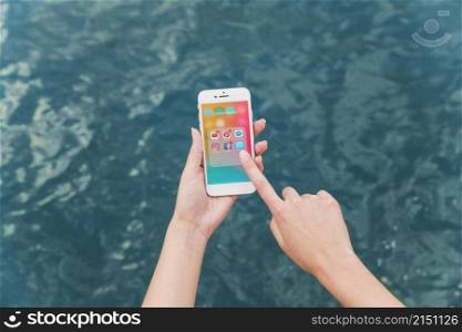 woman s hand using cellphone with social media notifications screen