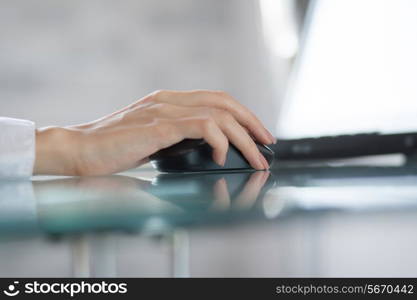 Woman`s hand using cordless mouse in the office