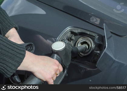 Woman?s hand when fueling a sports car with fuel E10