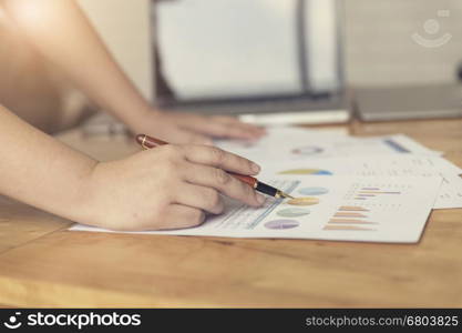 woman's hand working with business document and laptop computer notebook for working concept, selective focus and vintage tone