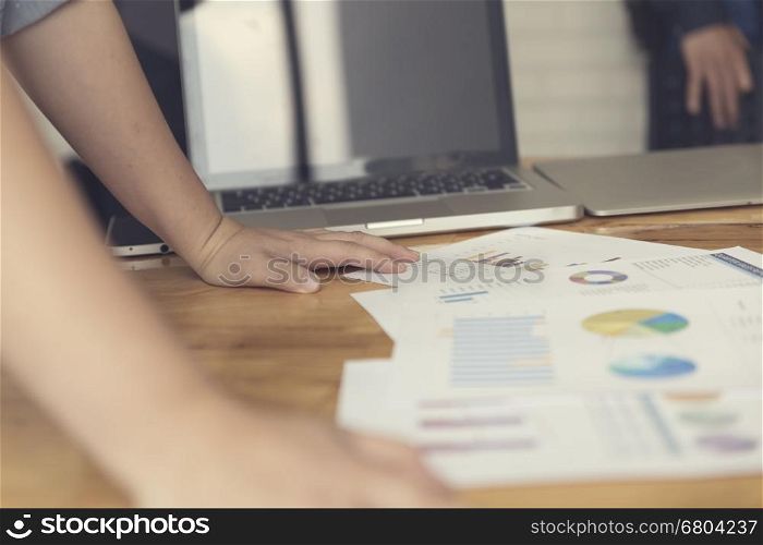 woman's hand working with business document and laptop computer notebook for working concept, selective focus and vintage tone