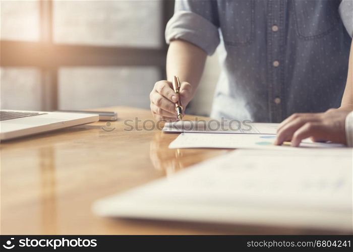woman's hand working with business document and laptop computer notebook for working concept, selective focus and vintage tone