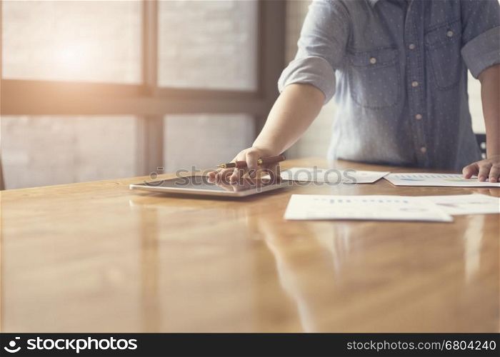 woman's hand working with business document and tablet for working concept, selective focus and vintage tone