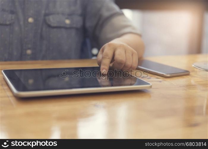 woman's hand working with tablet and smartphone for working concept, selective focus and vintage tone