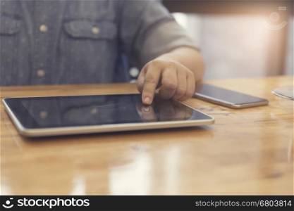 woman's hand working with tablet and smartphone for working concept, selective focus and vintage tone