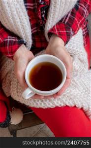 Woman’s hands are holding white cup of tea or coffee dressed in red and white festive clothes.. woman female holdingcup tea coffee red festive clothes christmas new year valentine
