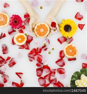 woman s palm with grapefruit petals flowers clear white water