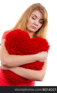 Woman sad girl hugging red heart love symbol . Woman blonde sad unhappy girl hugging red heart shaped big pillow studio shot on white. Heartbroken young female.