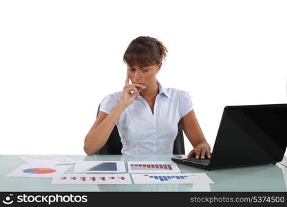 Woman sat at desk surrounded by graphs