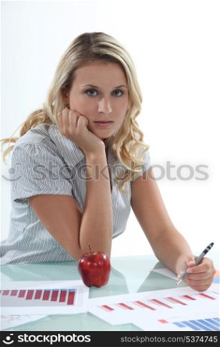 Woman sat at desk working on graphs