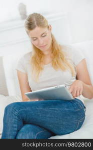 Woman sat on sofa with tablet computer