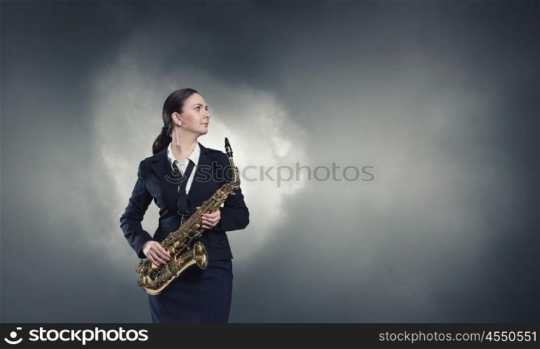 Woman saxophonist. Young woman in suit with saxophone in hands