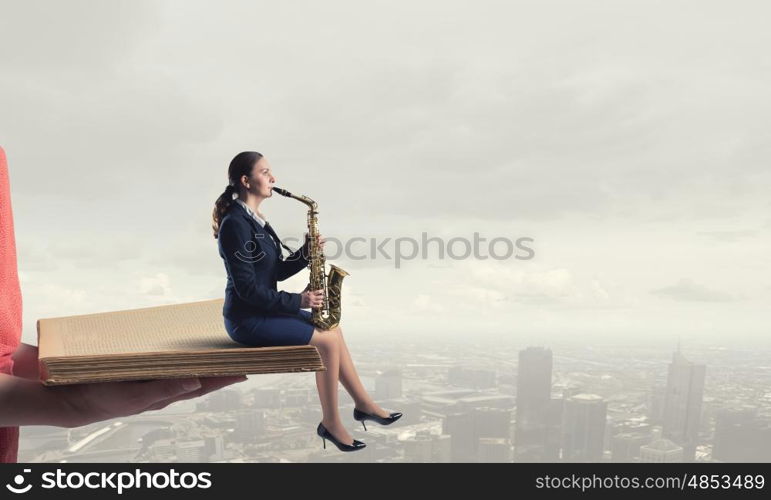 Woman saxophonist. Young woman in suit with saxophone in hands