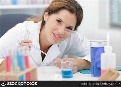 woman scientist adding liquid to test tube