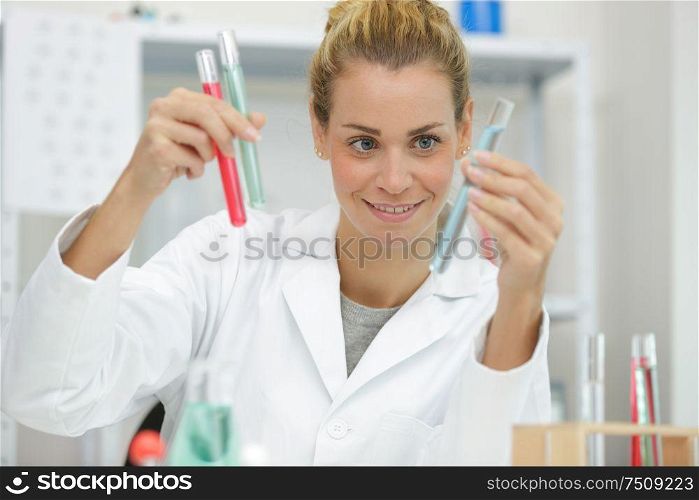 woman scientist holding test tube with pipettes