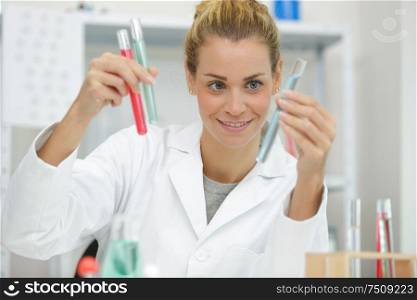 woman scientist holding test tube with pipettes