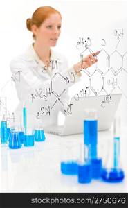 Woman scientist in laboratory with laptop and chemical formula