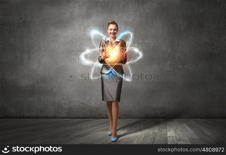Woman scientist presenting atom research concept. Attractive businesswoman holding glowing atom in hands