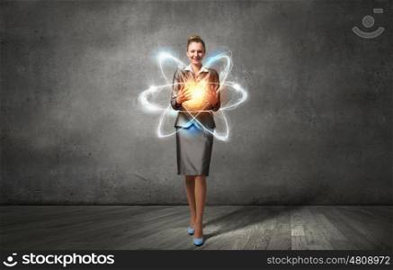 Woman scientist presenting atom research concept. Attractive businesswoman holding glowing atom in hands