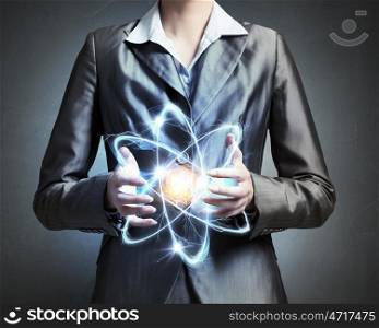 Woman scientist presenting atom research concept. Close up of businesswoman holding glowing atom in hands