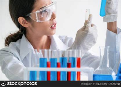 Woman scientist working in laboratory and examining biochemistry sample in test tube. Science technology research and development study concept.