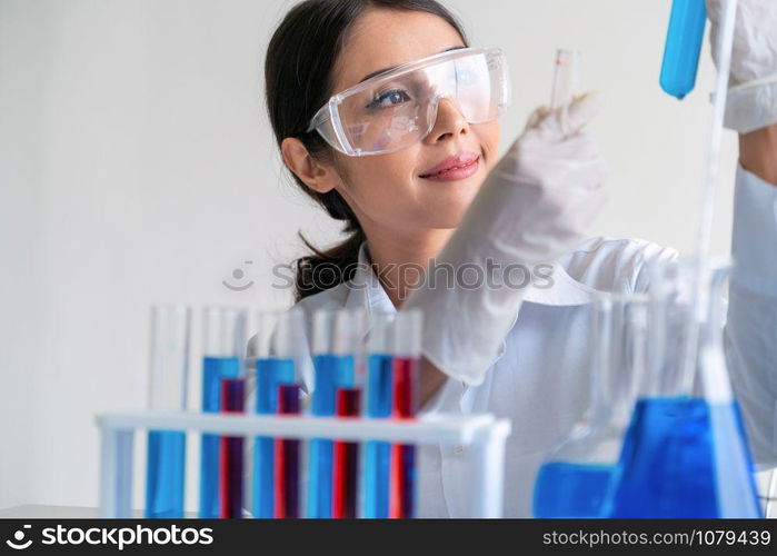 Woman scientist working in laboratory and examining biochemistry sample in test tube. Science technology research and development study concept.