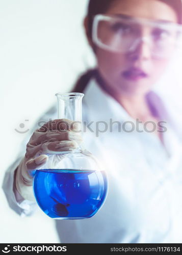 Woman scientist working in laboratory and examining biochemistry sample in test tube. Science technology research and development study concept.