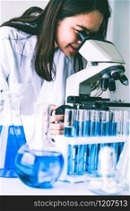 Woman scientist working in laboratory and examining biochemistry sample in test tube. Science technology research and development study concept.. Scientist working in biochemistry laboratory.