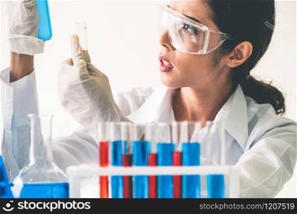 Woman scientist working in laboratory and examining biochemistry sample in test tube. Science technology research and development study concept.. Scientist working in biochemistry laboratory.