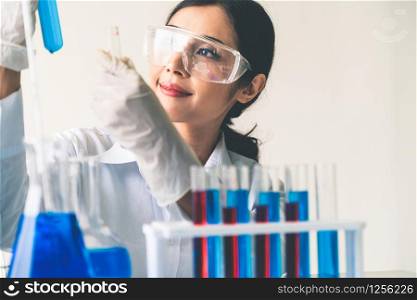 Woman scientist working in laboratory and examining biochemistry sample in test tube. Science technology research and development study concept.