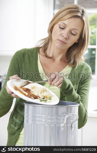 Woman Scraping Food Leftovers Into Garbage Bin