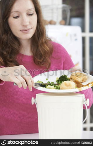 Woman Scraping Food Leftovers Into Garbage Bin