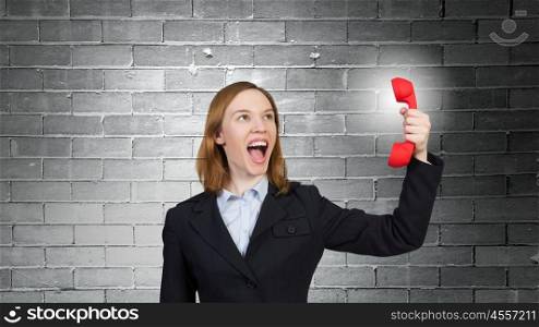 Woman scream in red receiver. Young businesswoman with red phone receiver in hands