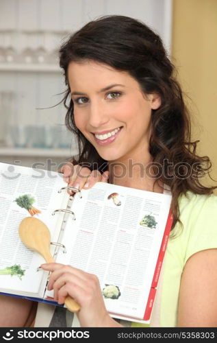 Woman searching for recipe in cook book