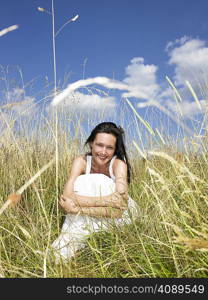 Woman seated in a field, smiling