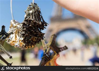 Woman selling small Eiffel Towers in the gardens of the Eiffel Tower, the main attraction in Paris, France