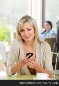 Woman Sending Text Message In Cafe